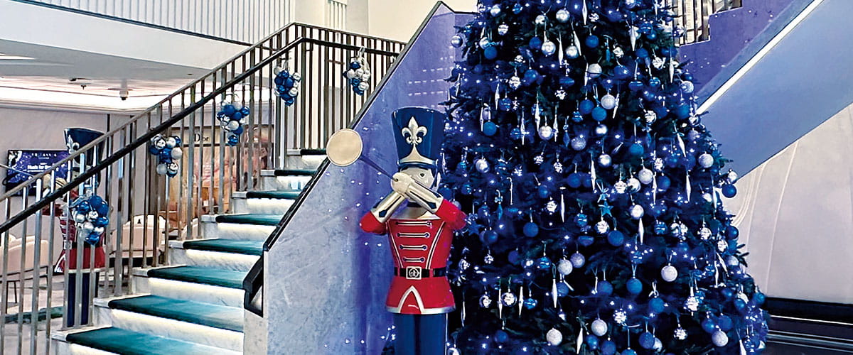 A Christmas tree and nutcrackers decorating the staircase in the Atrium on Spirit of Adventure